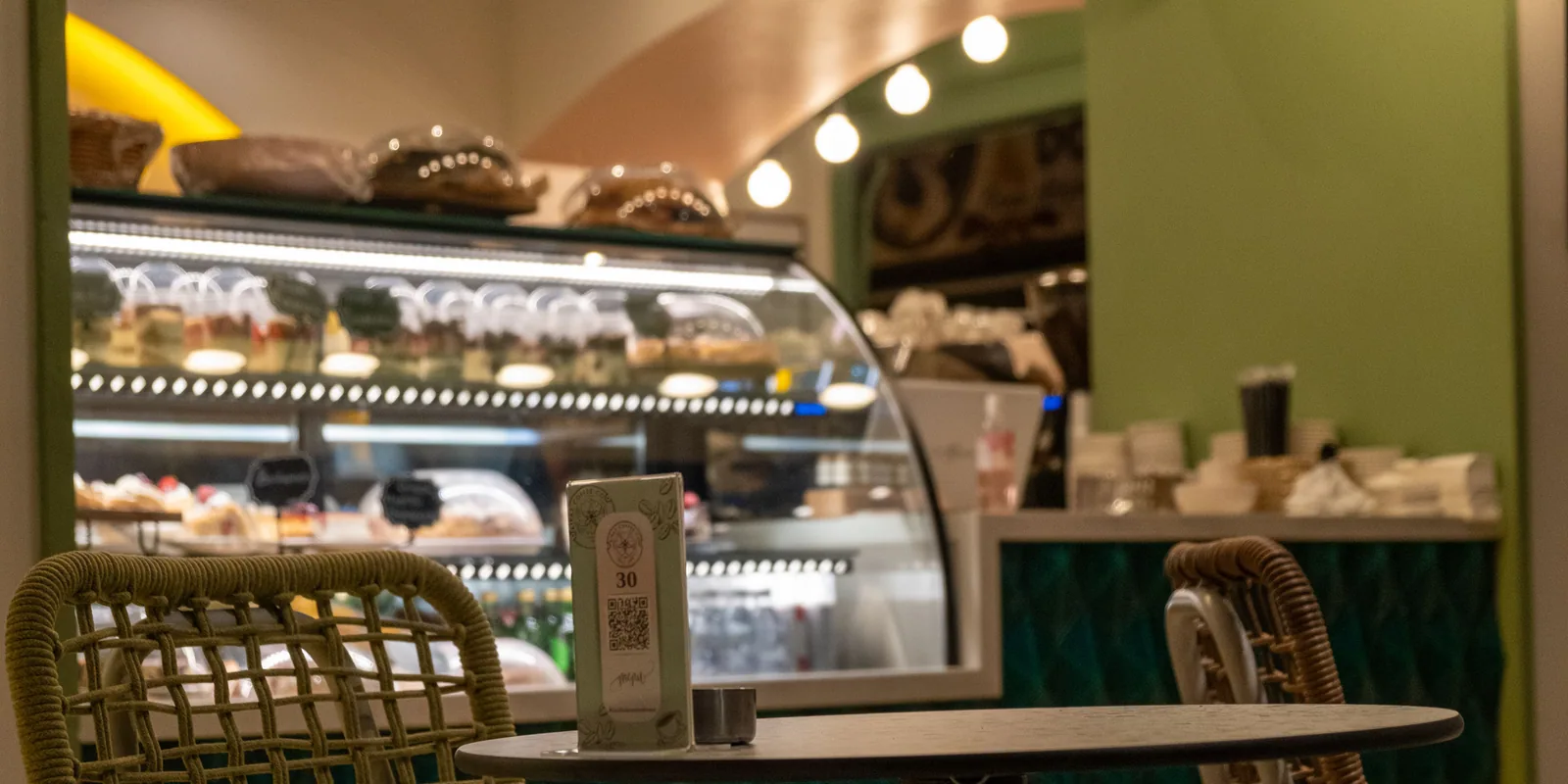 A small printed card with a QR code standing on a café table.